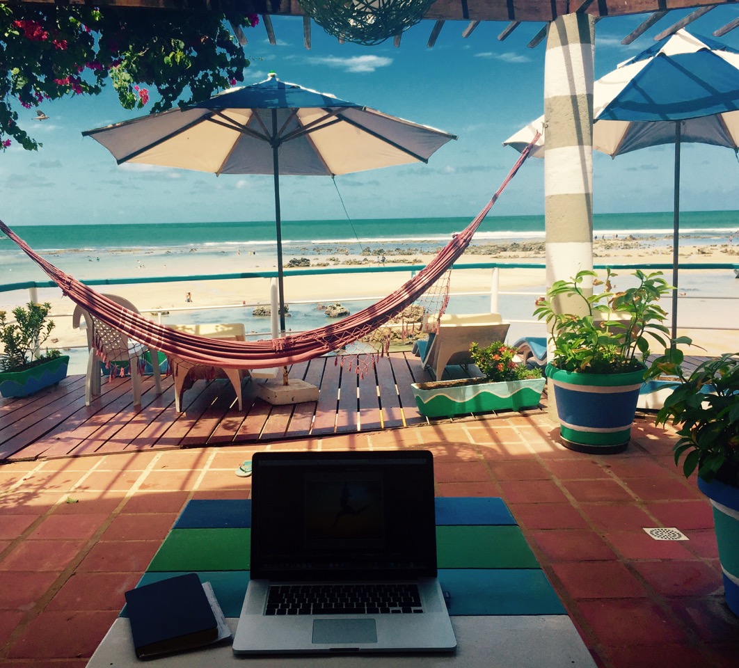 Digitale Nomaden nehmen den Laptop mit an den Strand
