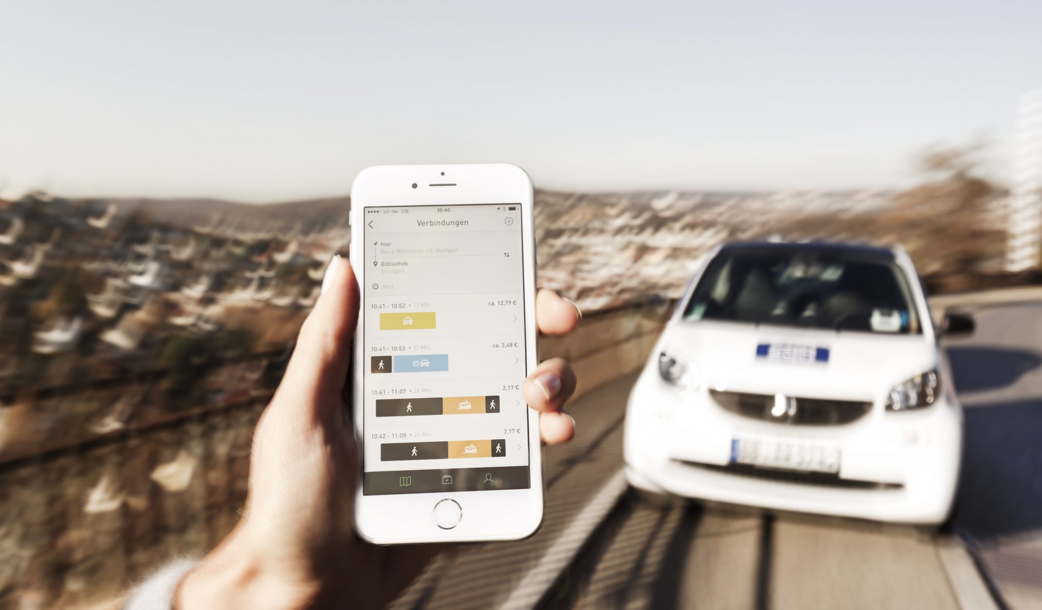 Handy mit der geöffneten noovel App vor Auto
