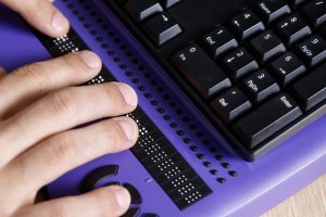 Blinde Person verwendet Computer mit Braillezeile