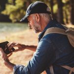 Senior man with tab looking for location