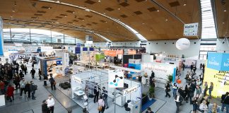 Halle mit Menschen und Ausstellern an Ständen