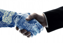 Roboterarm und Menschenarm geben sich die Hand