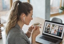 Im Büro oder Homeoffice? Wie organisieren sich Teams einfacher? Frau sitzt zu Hause am Laptop und tirnkt einen Cafe