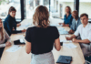 Rückansicht einer Geschäftsfrau, die bei einem Meeting im Büro spricht. Weibliche Managerin, die ein Meeting mit ihrem Team im Sitzungssaal des Büros hat.