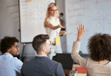 Drei Personen, die an einem Personalentwicklung Training teilnehmen, eine Person meldet sich.