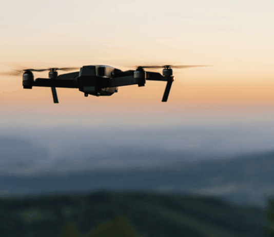 Drohne am Himmel, im Hintergrund sieht man Landschaft
