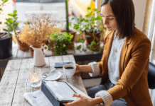 Geschäftsfrau sitzt in einem Café mit digitalem Tablet und liest Artikel. Symbolbild zum Thema Medienpräsenz
