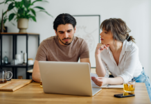 Warum der Weg zum Eigenheim so kompliziert geworden ist Symbolbild für Artikel: Warum der Weg zum Eigenheim so kompliziert geworden ist; Mann und Frau besprechen etwas und sitzen am Laptop