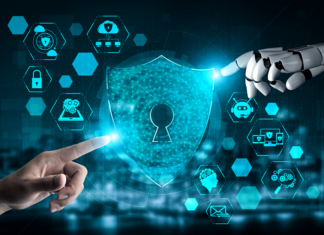 menschliche Hand und Roboterhand zeigen auf Cybersecurity Symbol